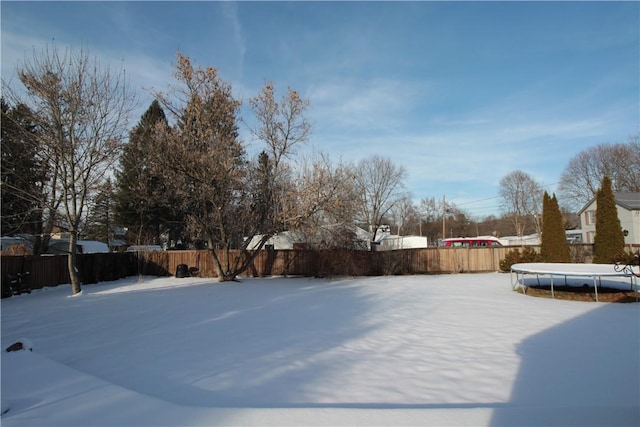 yard layered in snow featuring a trampoline