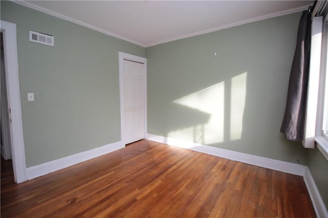 unfurnished room with crown molding and dark wood-type flooring