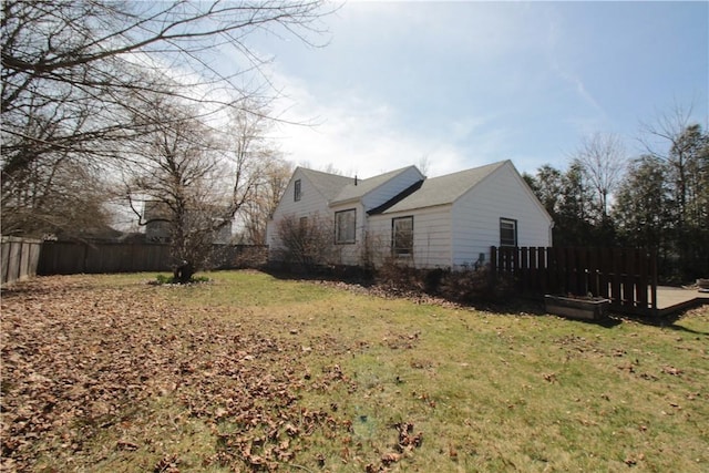 view of side of home featuring a fenced backyard and a lawn