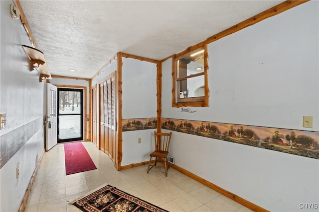 hall featuring a textured ceiling