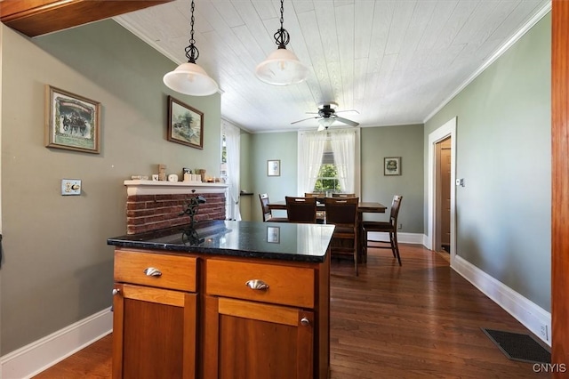 kitchen featuring decorative light fixtures, ceiling fan, dark hardwood / wood-style flooring, and ornamental molding