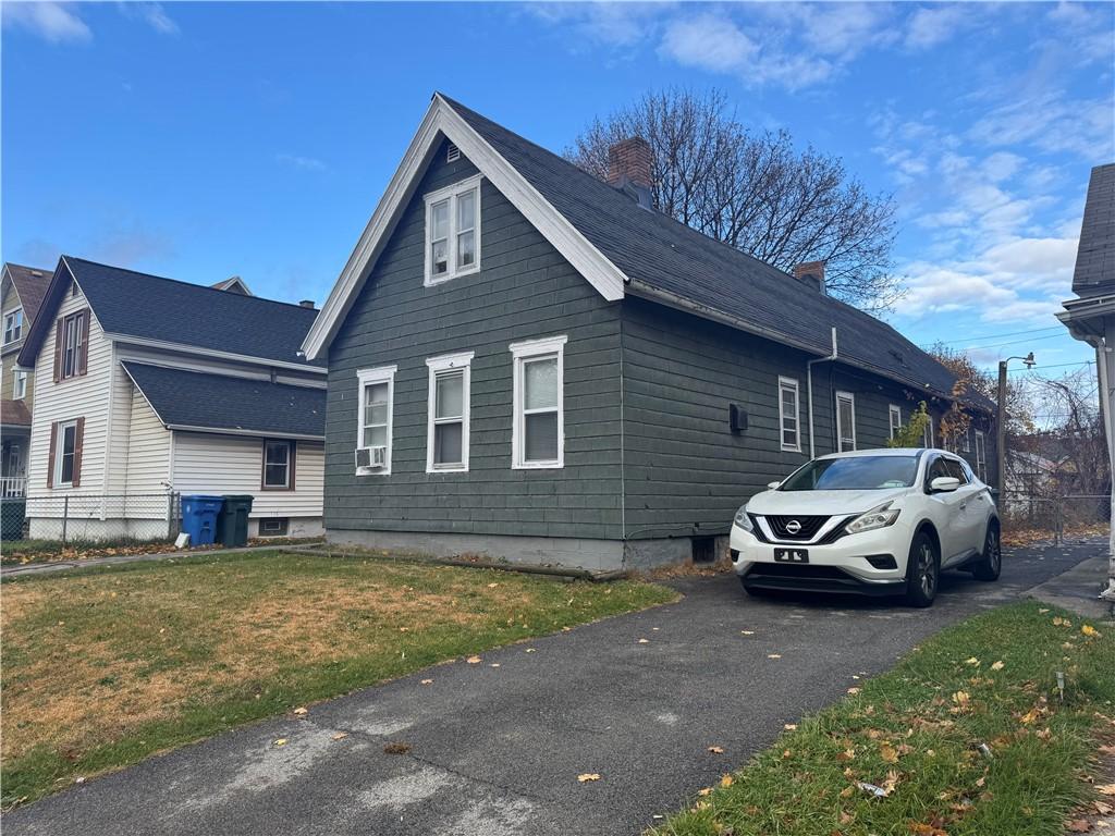 view of side of property with cooling unit and a yard