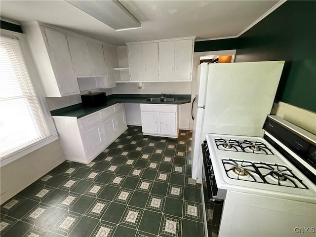 kitchen featuring a wealth of natural light, gas range gas stove, sink, and white cabinets