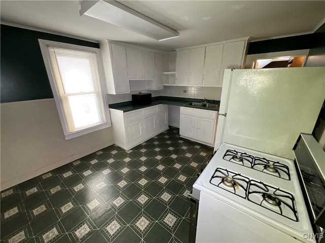 kitchen featuring white cabinets, white appliances, and sink