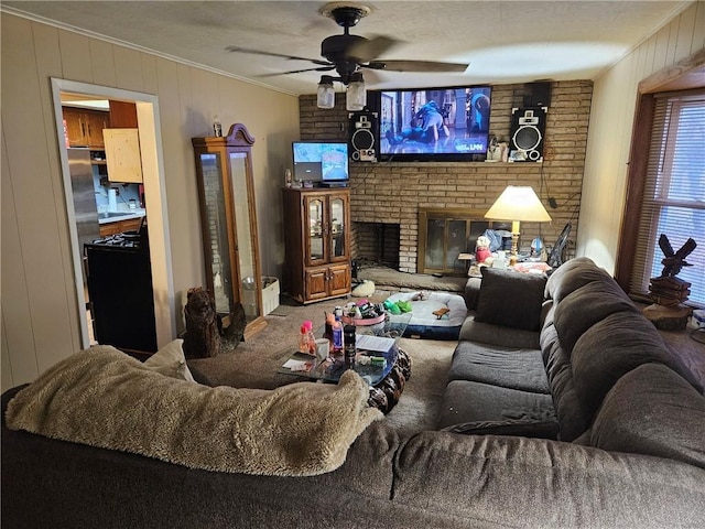 living room with ceiling fan, wooden walls, a fireplace, carpet, and ornamental molding