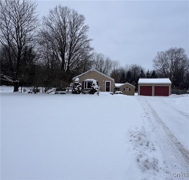 yard covered in snow with an outdoor structure and a garage