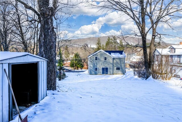 snowy yard featuring an outbuilding