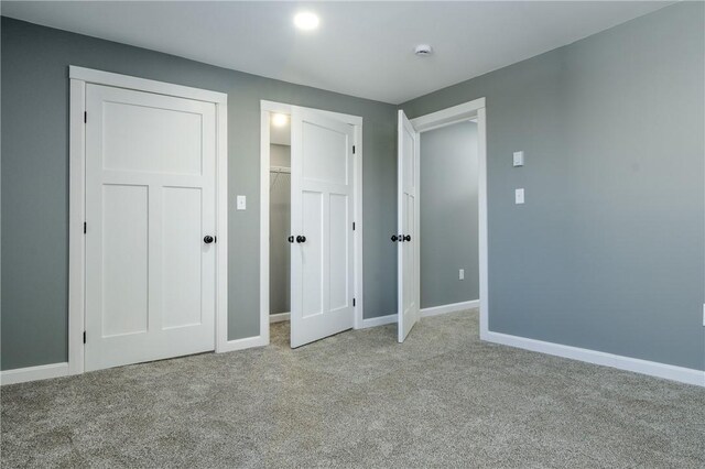 unfurnished bedroom featuring light carpet and a closet