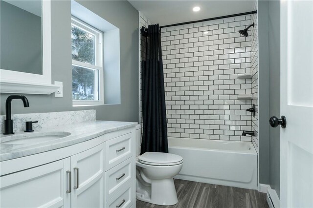 full bathroom with hardwood / wood-style flooring, shower / bath combo, toilet, and vanity