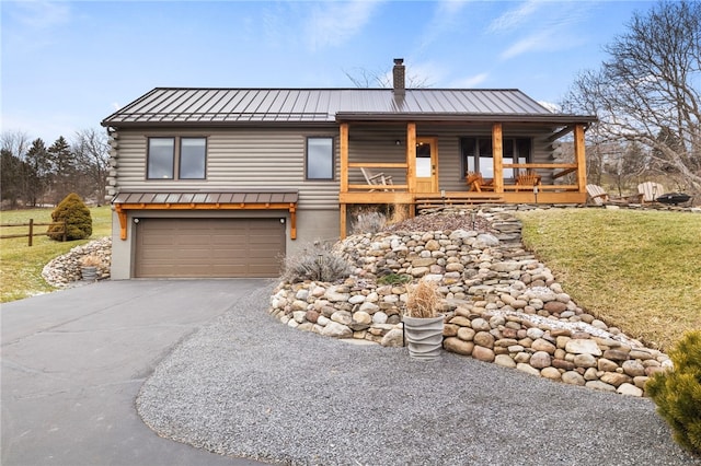 log home featuring covered porch, a front yard, and a garage