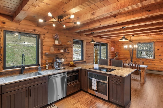 kitchen with beam ceiling, hanging light fixtures, log walls, and stainless steel appliances