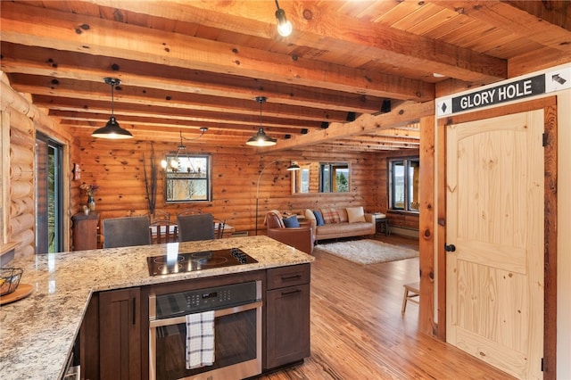 kitchen with pendant lighting, beamed ceiling, log walls, and oven