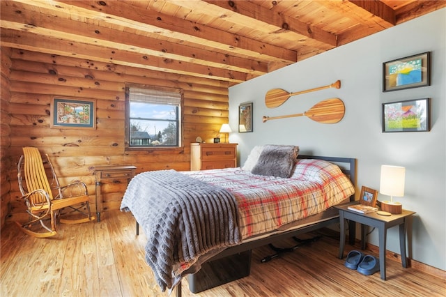 bedroom with light hardwood / wood-style floors, beam ceiling, wooden ceiling, and rustic walls