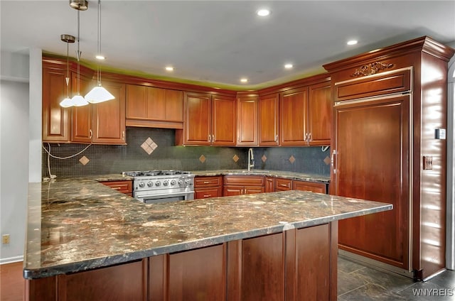 kitchen featuring stainless steel stove, hanging light fixtures, sink, kitchen peninsula, and dark stone counters