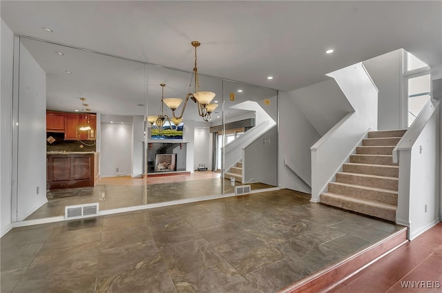 interior space featuring a brick fireplace and an inviting chandelier