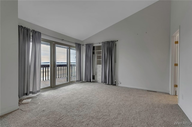 carpeted empty room featuring vaulted ceiling