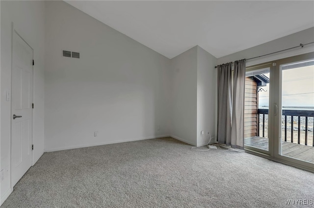 empty room with carpet floors and vaulted ceiling