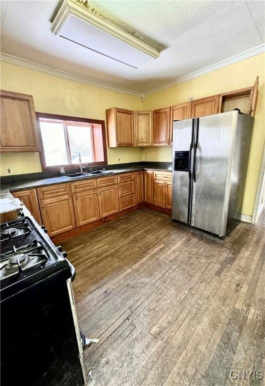 kitchen with black gas range, sink, dark hardwood / wood-style floors, a textured ceiling, and stainless steel fridge with ice dispenser