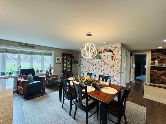 dining room with dark wood-type flooring and an inviting chandelier