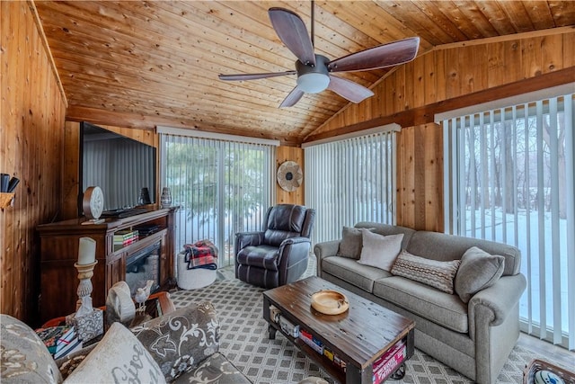 living room featuring lofted ceiling, wooden walls, a wealth of natural light, and wooden ceiling