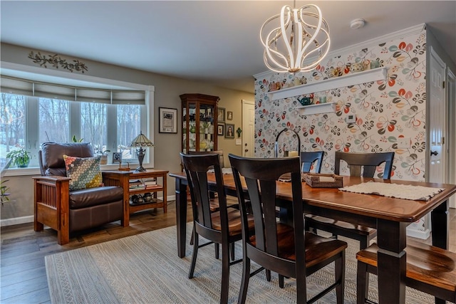 dining room with hardwood / wood-style flooring, ornamental molding, and an inviting chandelier