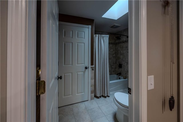 bathroom featuring shower / bathtub combination with curtain, tile patterned flooring, a skylight, and toilet