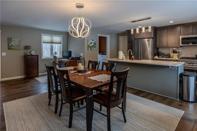 dining room featuring dark hardwood / wood-style flooring, a notable chandelier, and sink