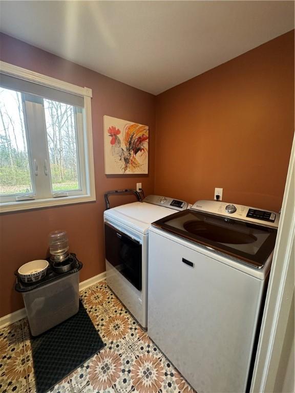 laundry room featuring independent washer and dryer and light tile patterned flooring