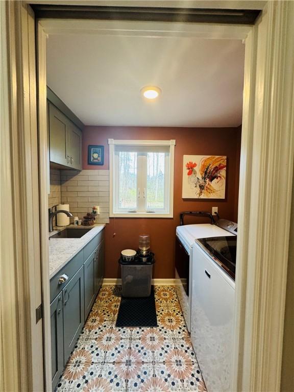 washroom featuring cabinets, separate washer and dryer, sink, and light tile patterned floors