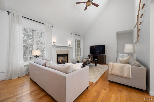 living room with ceiling fan, light hardwood / wood-style flooring, and high vaulted ceiling