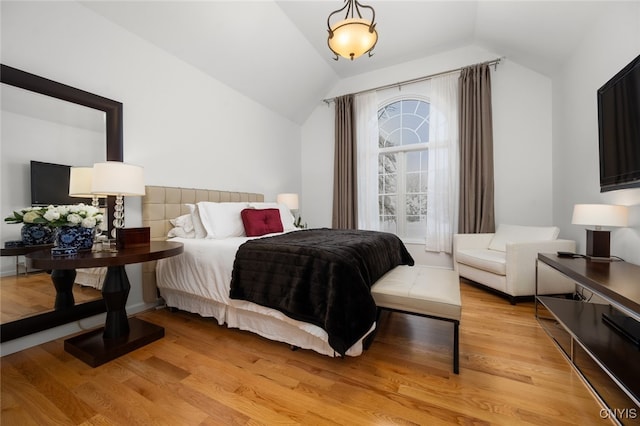 bedroom with light hardwood / wood-style floors and lofted ceiling