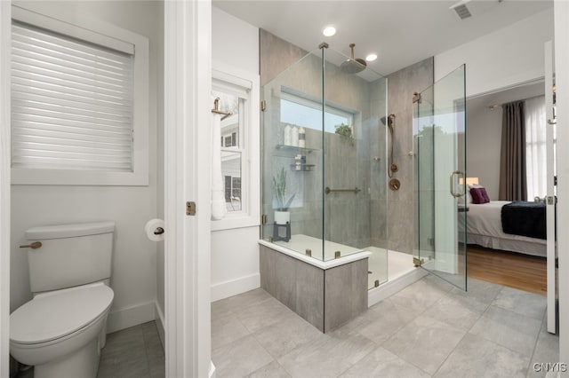 bathroom featuring tile patterned floors, toilet, and walk in shower