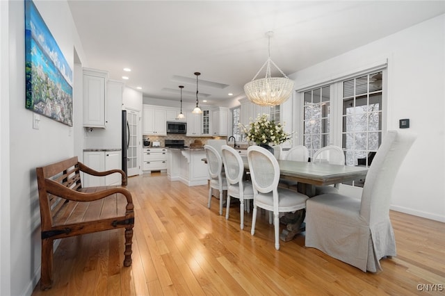 dining room featuring light hardwood / wood-style floors and a notable chandelier