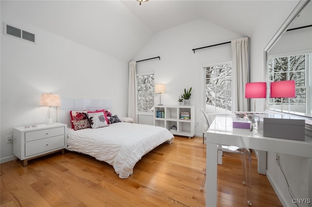 bedroom with light wood-type flooring and lofted ceiling