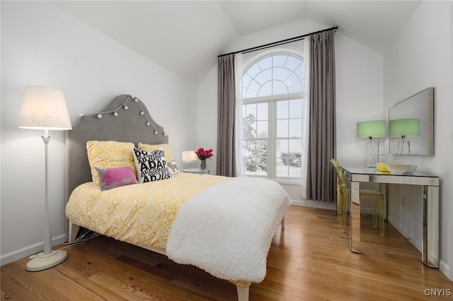 bedroom with hardwood / wood-style floors and lofted ceiling