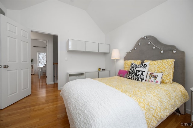 bedroom featuring wood-type flooring and vaulted ceiling