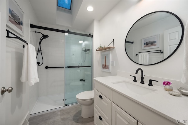 bathroom with vanity, toilet, and a shower with door