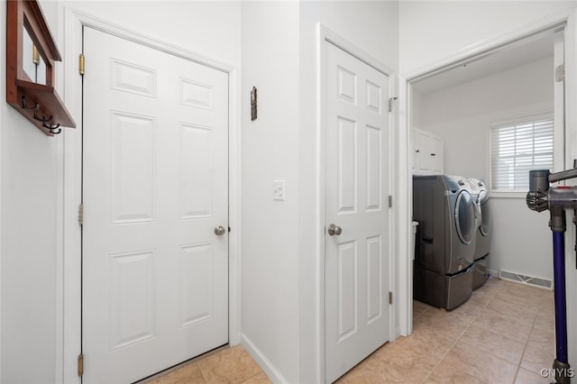 laundry area featuring cabinets, light tile patterned floors, and washing machine and dryer