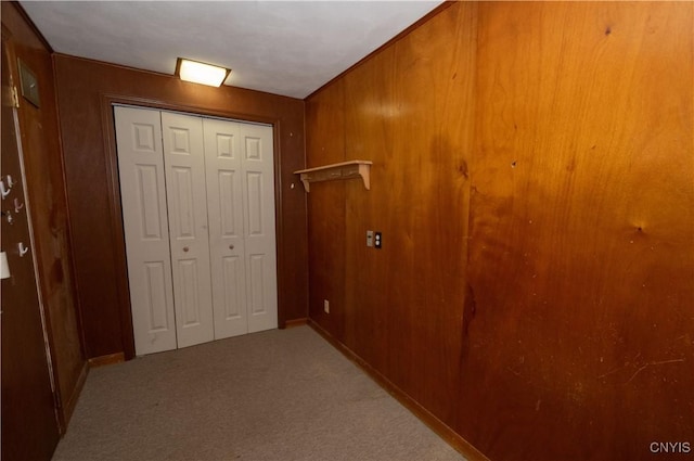 hall featuring wood walls and light carpet