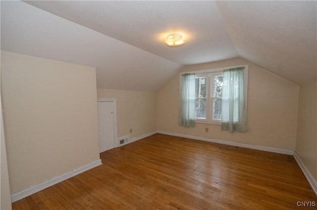 additional living space with wood-type flooring and lofted ceiling