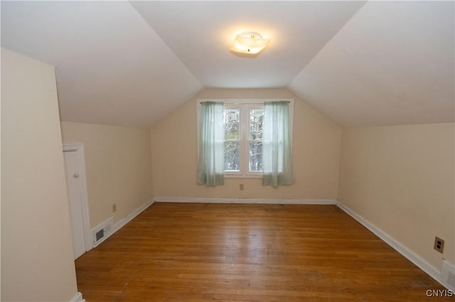 bonus room with lofted ceiling and hardwood / wood-style flooring