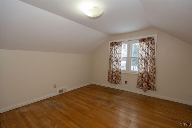 bonus room featuring hardwood / wood-style flooring and vaulted ceiling