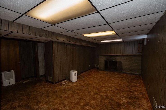 basement with dark colored carpet and wood walls