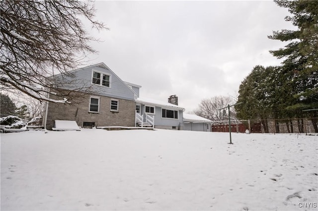 view of snow covered back of property