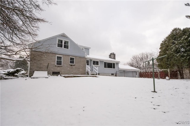 view of snow covered rear of property