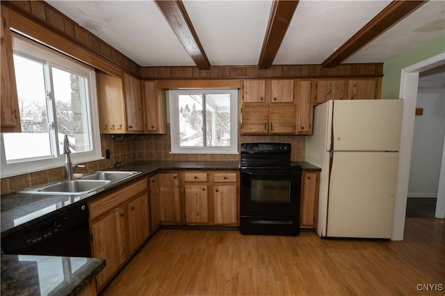 kitchen with sink, beamed ceiling, black appliances, and light hardwood / wood-style flooring