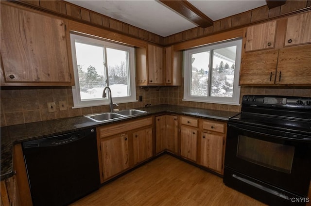 kitchen with beam ceiling, sink, black appliances, and light hardwood / wood-style flooring