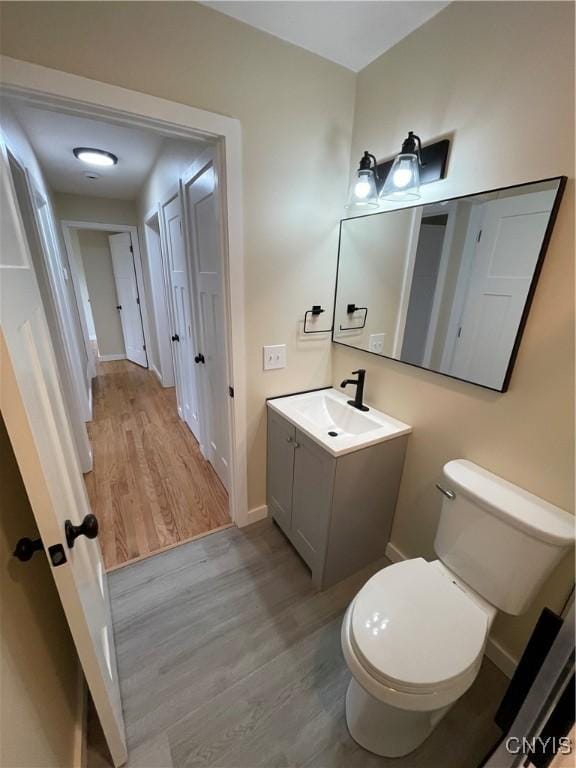 bathroom with vanity, toilet, and wood-type flooring