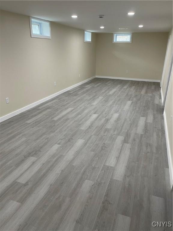 basement with a wealth of natural light and hardwood / wood-style flooring