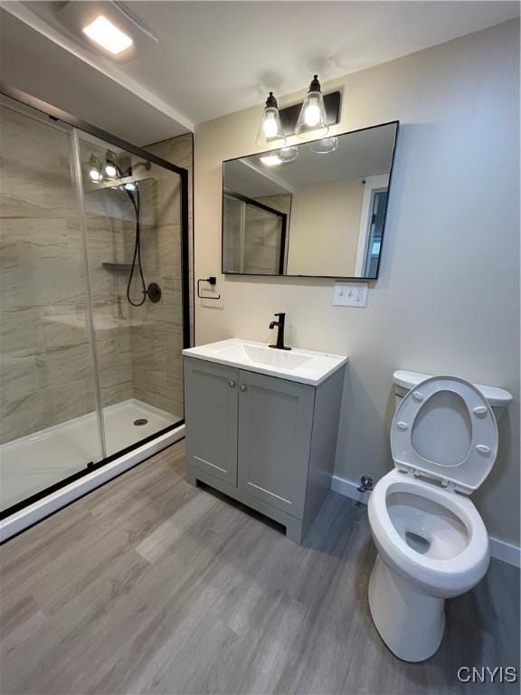 bathroom featuring toilet, vanity, wood-type flooring, and walk in shower